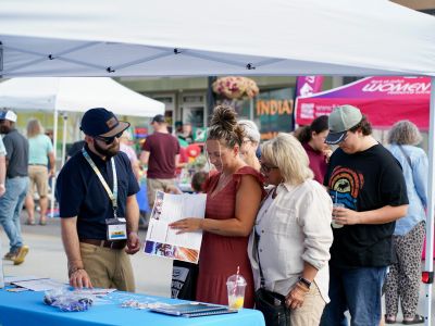 Planning staff show residents the Executive Summary during the 2025 Moose FM Block Party.